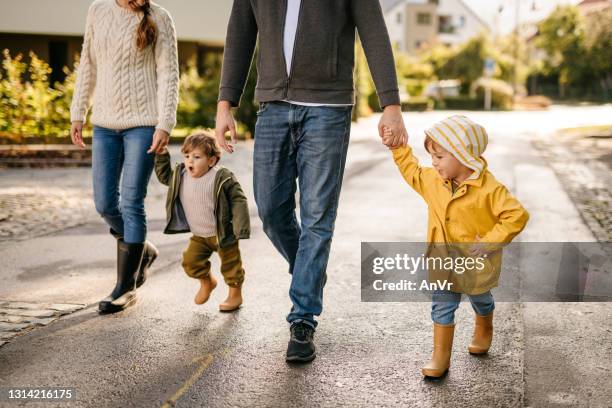 two little brothers on a walk with their parents - community vitality stock pictures, royalty-free photos & images