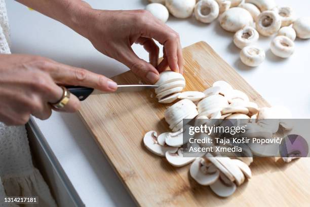 view of woman cutting up button mushrooms - white mushroom photos et images de collection