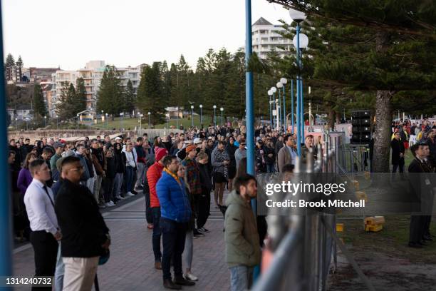 Crowds watch from behind fencing during the ANZAC day dawn service at Coogee on April 25, 2021 in Sydney, Australia. Anzac day is a national holiday...