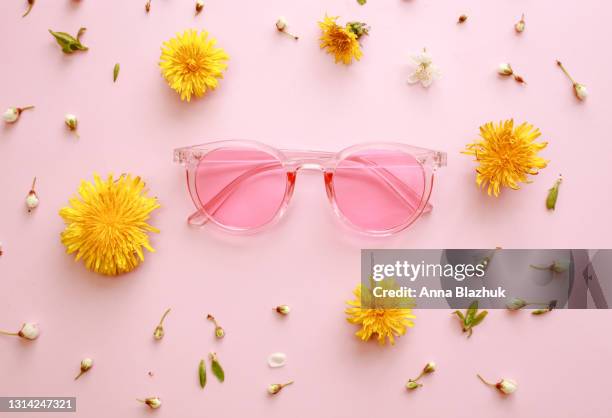 pink 90s retro style sunglasses and spring dandelion flowers over pink background - pink sunglasses stock pictures, royalty-free photos & images