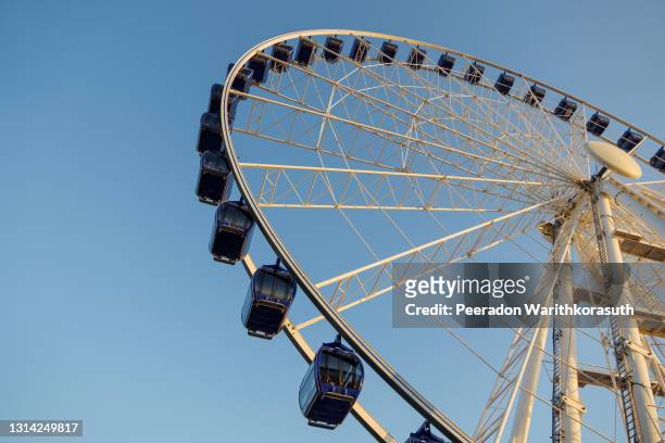 low angle view of white structure and blue cabin of ferris wheel with background of clear blue sunny sky. - dusseldorf germany stock pictures, royalty-free photos & images
