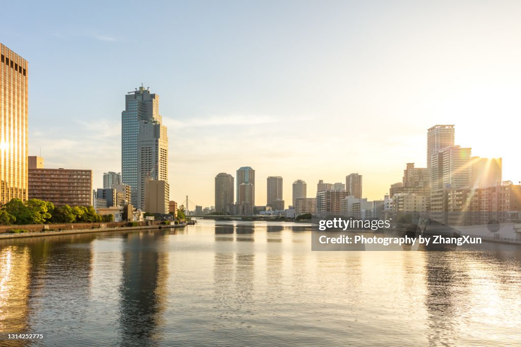 Sun rising over sumida river with skyscrapers of Tokyo downtown, Japan in the morning.
