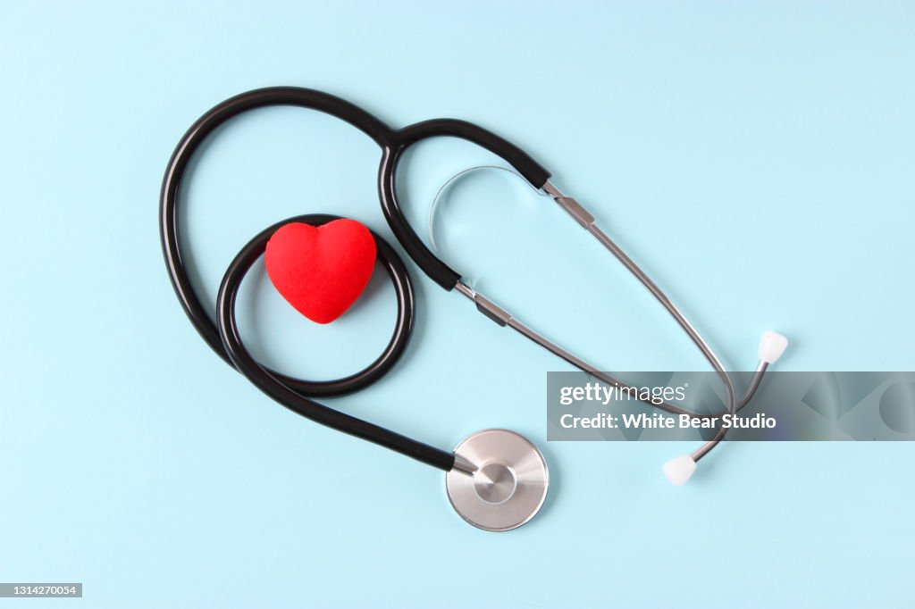 Stethoscoop en hart op houten kleurenachtergrond. Gezondheid, geneeskunde
