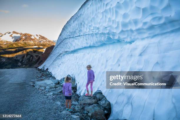 twee meisjes die sneeuwmuren op de berg van whistler onderzoeken. - whistler mountain stockfoto's en -beelden