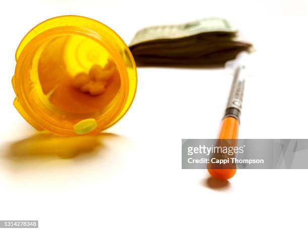 pills, bottle, syringe, and money over white background - oxycodone stock pictures, royalty-free photos & images