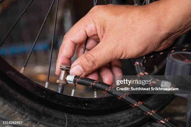 cropped hand of man pumping bicycle tires - air pump stock pictures, royalty-free photos & images