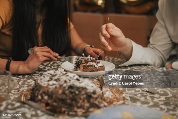 young couple sharing chocolate cake in a coffee bar - foodie stockfoto's en -beelden