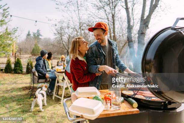 gemeinsam ein klassisches barbecue am 4. juli vorbereiten - couple grilling stock-fotos und bilder