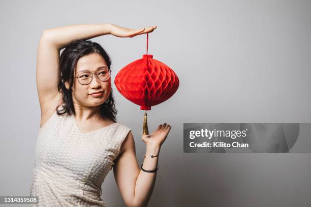 portrait of asian woman in a pretty dress holding a chinese new year red lantern - woman red lantern stock pictures, royalty-free photos & images