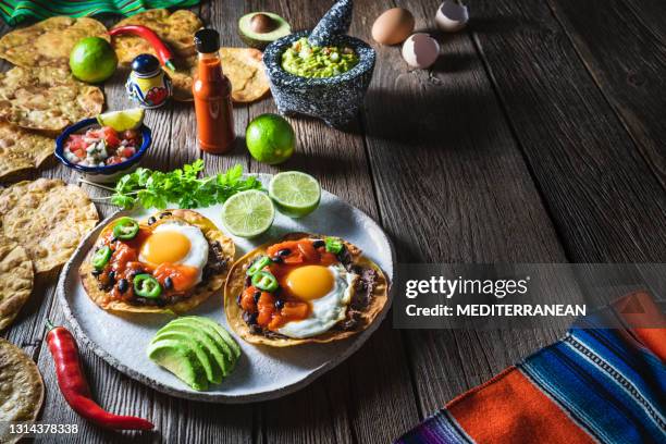 huevos rancheros are mexican ranchero eggs breakfast with pico de gallo and guacamole - tortilla flatbread stock pictures, royalty-free photos & images