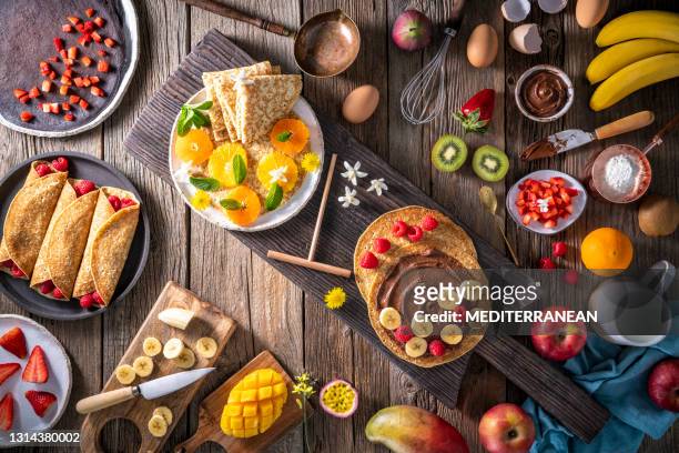 crepes arrangement with fruits, berries, cocoa cream and varied vegetarian food - nutella pancake stock pictures, royalty-free photos & images
