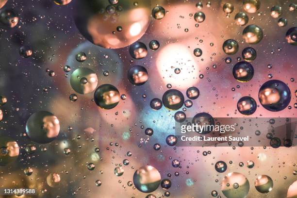 pink, purple and blue oil and water drops abstract background - laurent sauvel photos et images de collection