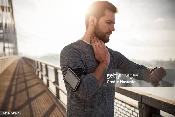 checking smart watch for a pulse trace after running - running man heartbeat stock pictures, royalty-free photos & images