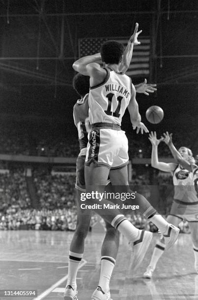 Denver Nuggets guard Chuck Williams throws a pass behind Kareem Abdul-Jabbar to teammate Dan Issel during an NBA game against the Los Angeles Lakers...