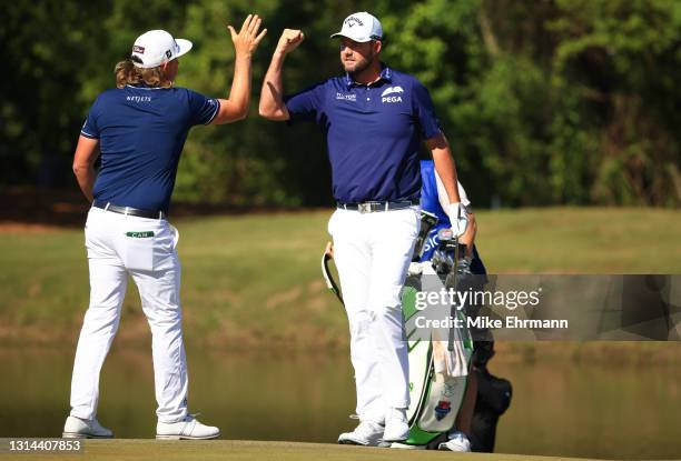 Cameron Smith of Australia and Marc Leishman of Australia react to a birdie putt on the 16th green during the final round of the Zurich Classic of...