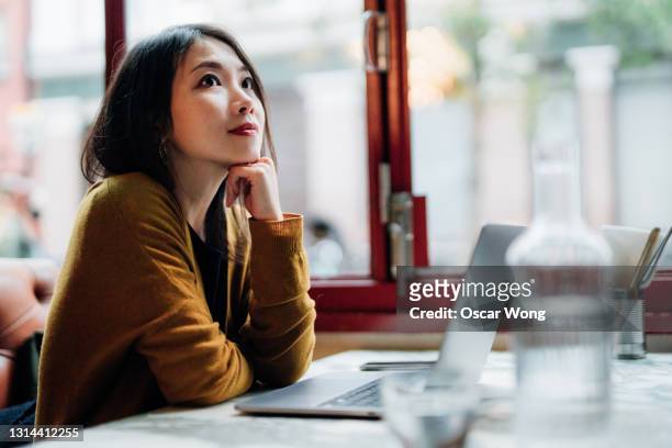 young woman working with laptop at cafe - 思索にふける ストックフォトと画像