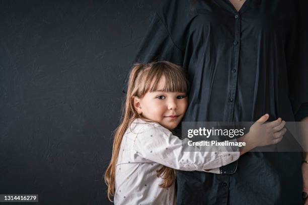 eine mutter umarmt ihre kleine tochter - straßenhobel stock-fotos und bilder