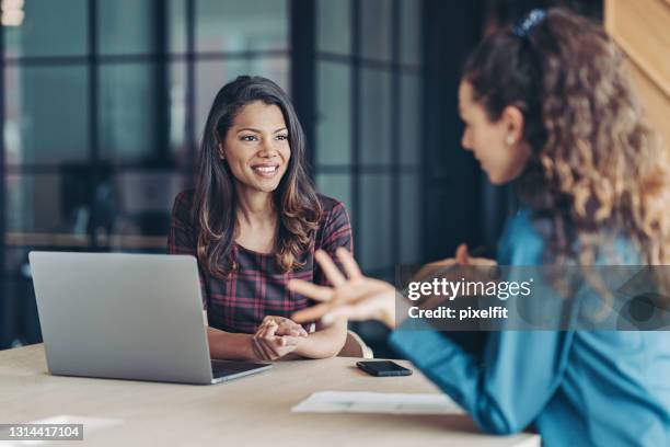 dos jóvenes discutiendo negocios - business talk frase corta fotografías e imágenes de stock