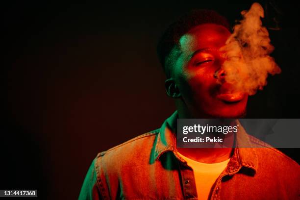 smoking cigar under the neon lights - black man smoking stock pictures, royalty-free photos & images
