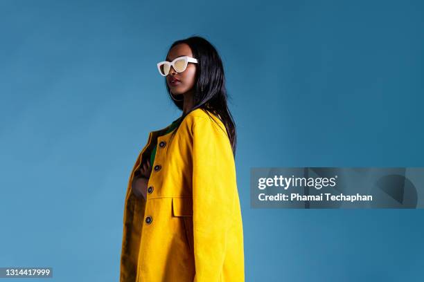 fashionable woman in a yellow coat - frau kleid stock-fotos und bilder