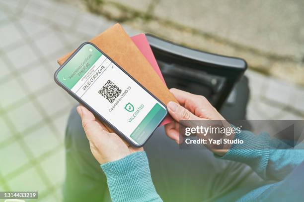 mid adult woman using a digital vaccine passport with smart phone in outdoor. - impfpass reisedokument stock-fotos und bilder