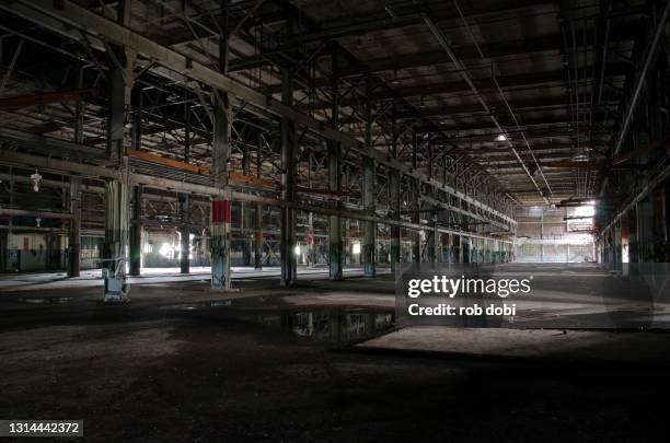 large empty space inside a decaying abandoned industrial factory - abandoned warehouse stock-fotos und bilder