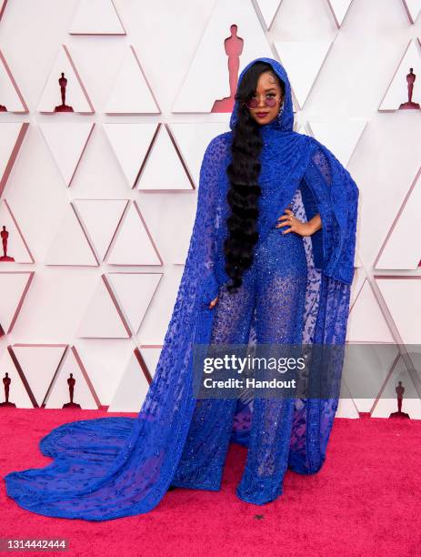 In this handout photo provided by A.M.P.A.S., H.E.R. Attends the 93rd Annual Academy Awards at Union Station on April 25, 2021 in Los Angeles,...