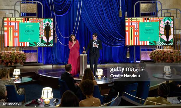 In this handout photo provided by A.M.P.A.S., Alice Doyard and Anthony Giacchino accept the Documentary award for 'Colette' onstage during the 93rd...