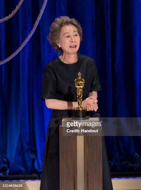 In this handout photo provided by A.M.P.A.S., Yuh-Jung Youn accepts the Oscar for Best Actress in a Supporting Role for "Minari" onstage during the...