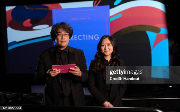 In this handout photo provided by A.M.P.A.S., Bong Joon Ho presents the Oscar with interpreter Sharon Choi for Best Directing during the 93rd Annual...