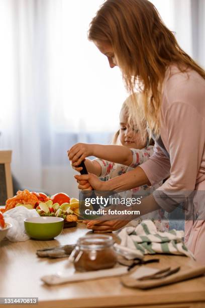 彼女の母親とバナナをつぶす小さな女の子 - potato masher ストックフォトと画像