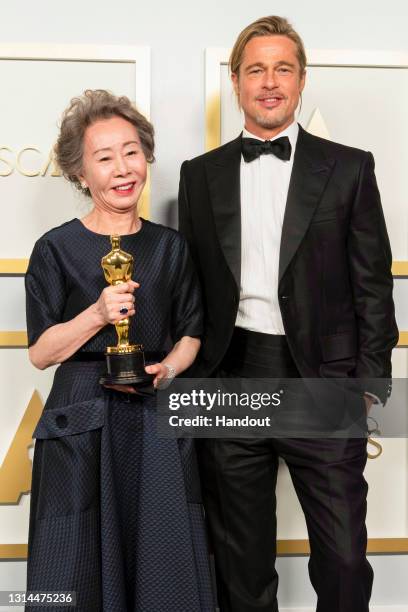 In this handout photo provided by A.M.P.A.S., Yuh-Jung Youn poses backstage with the Oscar for Actress in a Supporting Role with Brad Pitt during the...