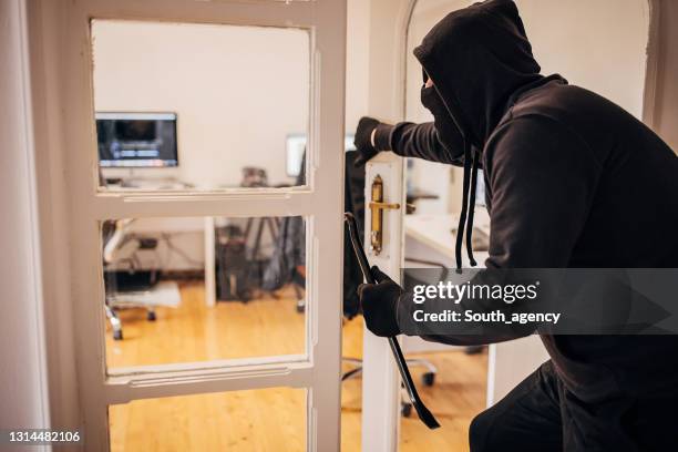 male criminal entering in office - burglar carried stock pictures, royalty-free photos & images