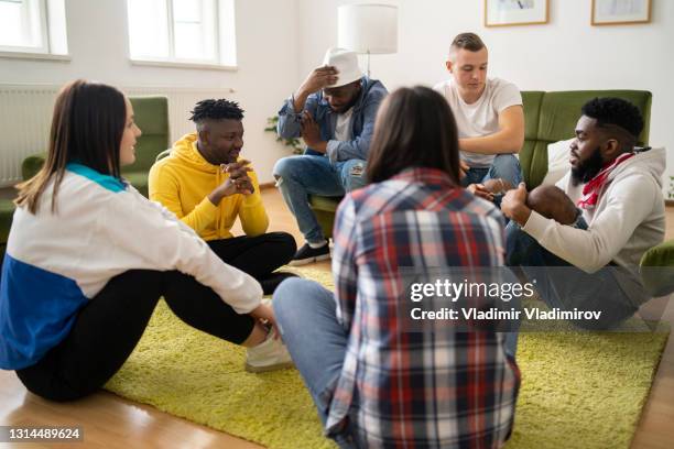 eine gruppe von erwachsenen, die im kreis sitzen, führen eine freundschaftliche diskussion - things that are round stock-fotos und bilder