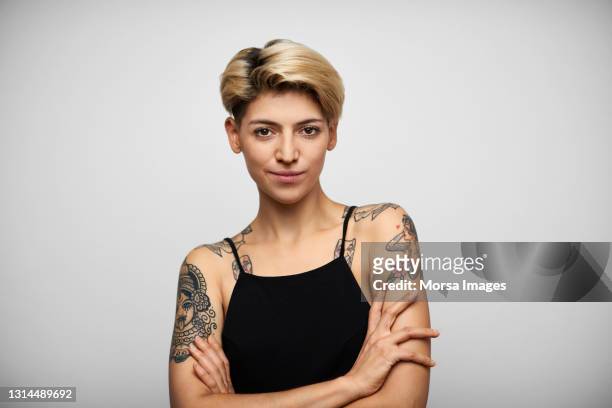 hispanic female hipster with arms crossed - tatuaje fotografías e imágenes de stock