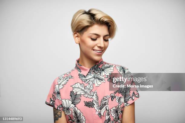 latin american woman in shirt against gray background - mirar hacia abajo fotografías e imágenes de stock