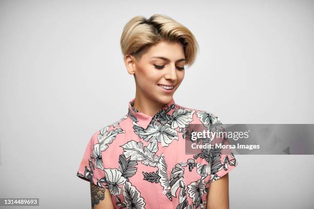 latin american woman in shirt against gray background - regarder vers le bas photos et images de collection