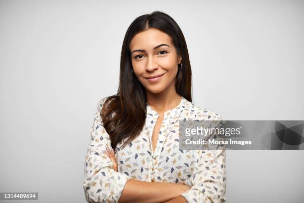 confident hispanic woman against gray background - etnia foto e immagini stock