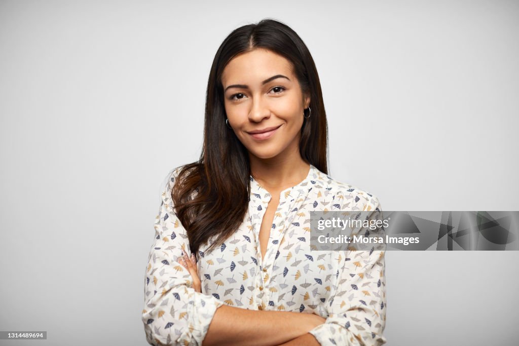 Confident Hispanic Woman Against Gray Background