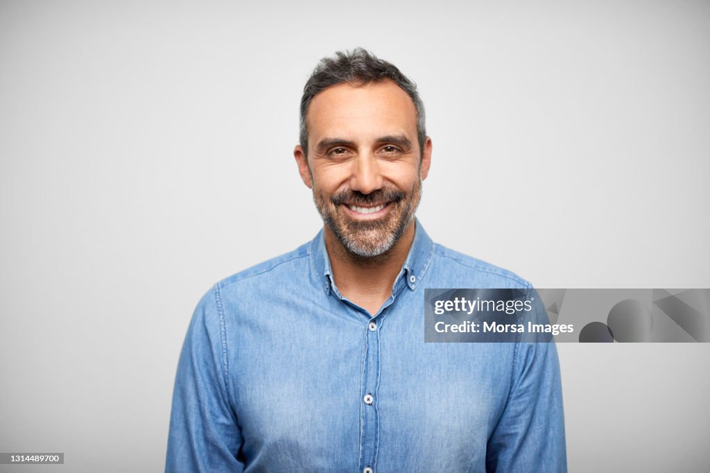 Happy Mature Hispanic Man Against White Background