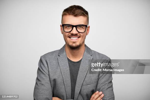 smiling hispanic businessman against gray background - gray jacket - fotografias e filmes do acervo