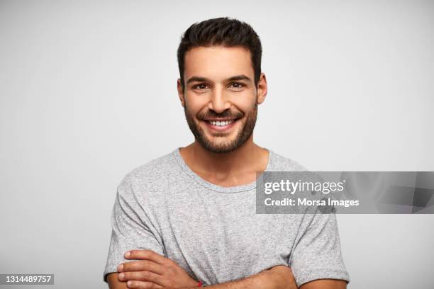 smiling hispanic man against white background - grey shirt ストックフォトと画像