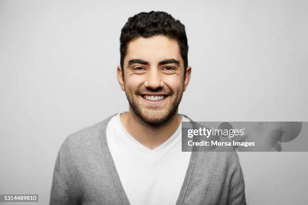 handsome latin american man against white background - 20s confident young male stockfoto's en -beelden