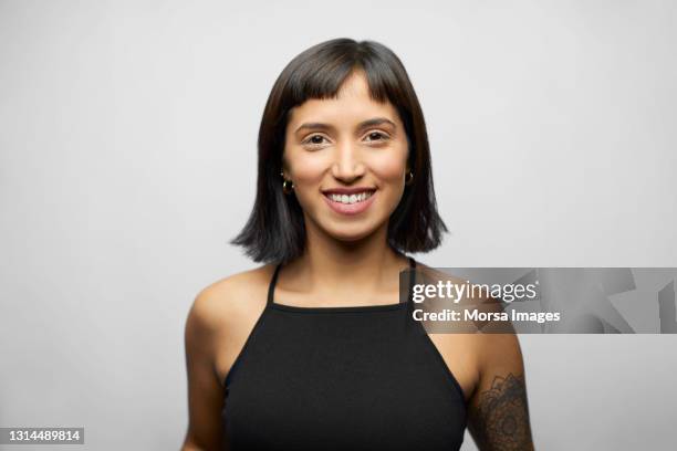 smiling hispanic female against gray background - bangs stock pictures, royalty-free photos & images