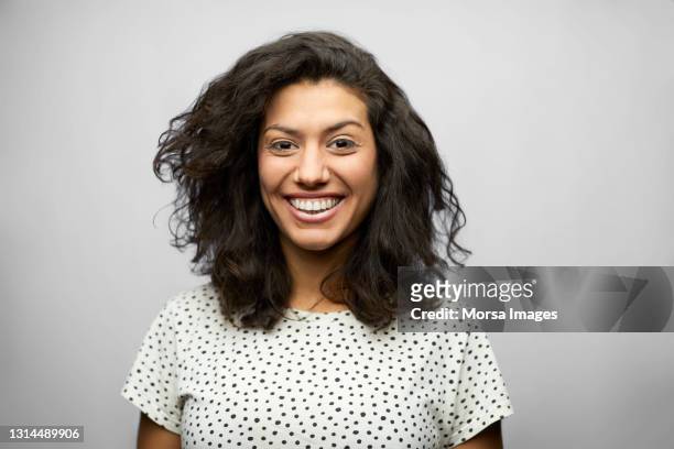 smiling latin american woman against gray background - latin beauty stockfoto's en -beelden