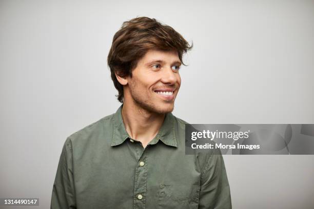 handsome hispanic man against white background - wegsehen stock-fotos und bilder