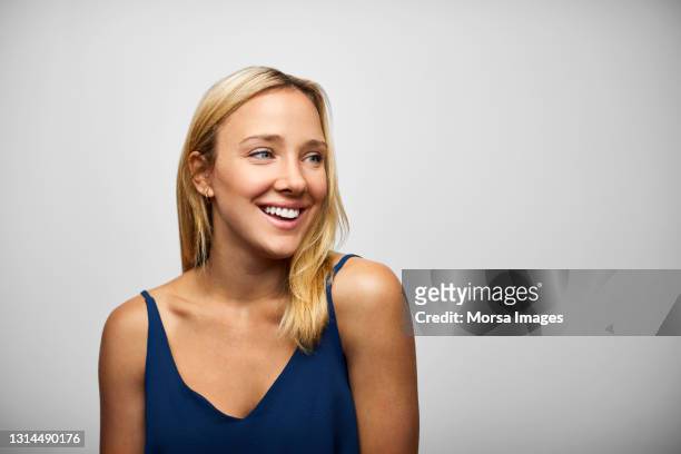 happy hispanic woman against gray background - capelli biondi foto e immagini stock