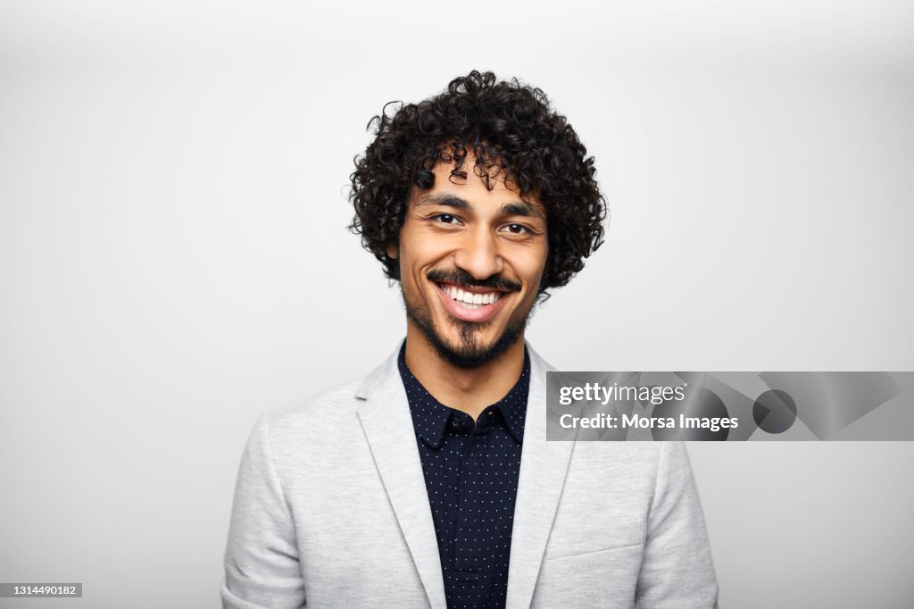 Smiling Latin American Businessman Against Gray Background