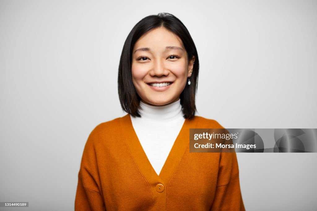 Confident Hispanic Businesswoman Against White Background