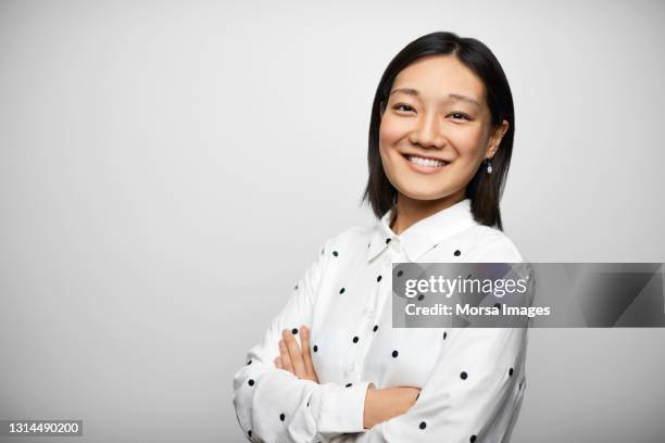 confident latin american businesswoman against gray background - waist up stockfoto's en -beelden